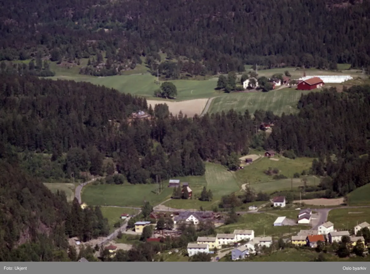Skulleruddumpa, der Norstrandsveien kommer ut i Enebakkveien (nåværende E6). Skullerud gård i bakgrunnen. (Flyfoto)