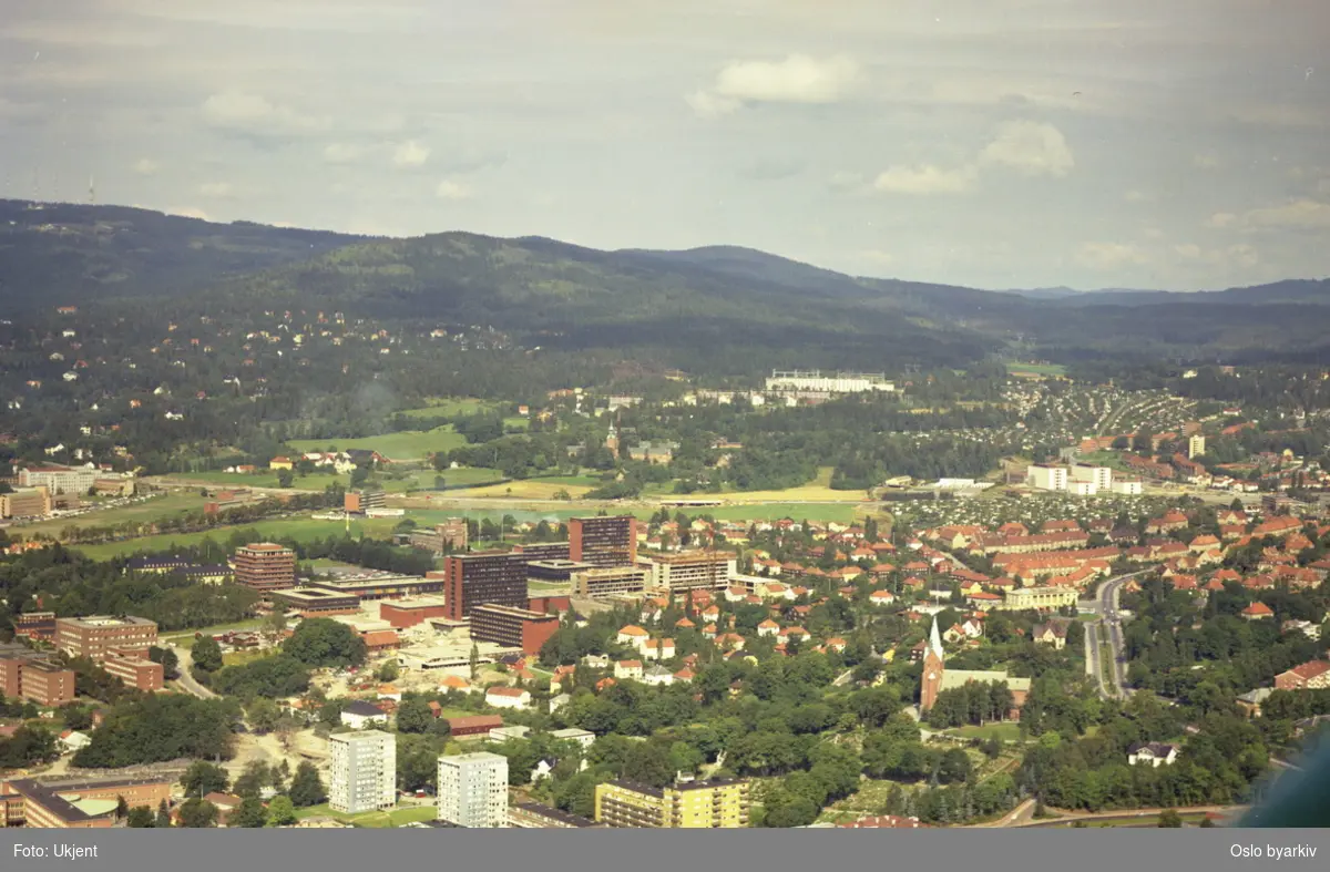 Boligblokker i Kirkeveien, og Vestre Aker kirke i front. Universitetet i Oslo lenger bak, Sognsveien til høyre. Gaustad og Sogn i bakgrunnen. (Flyfoto)