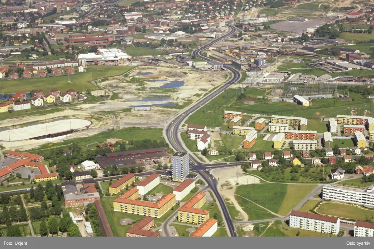 Teisenkrysset, hvor Ringveien og Strømsveien møtes. Agmund Bolts vei til venstre for Ringveien i front. Hovin ungdomskole og Valle-Hovin skøytestadion bak Strømsveien til venstre. Karl Staaffs vei går mellom boligblokkene til høyre. I dag ligger Valle-Hovin Idrettspark på det åpne feltet lenger bak. Økern i bakgrunnen.  (Flyfoto)