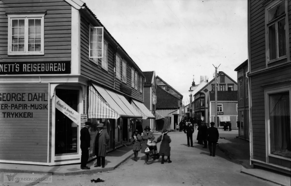 Storgata sett østover., Storgata sett østover fra S.Pettersson mot Torget.S.Pettersson til høyre..H.George Dahl til venstre..Bennets reisebeureau til venstre..Fotograf A.Groven til høyre.