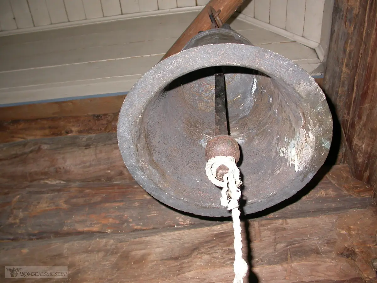 Kirkeklokke fra Hen kirke i Romsdalsmuseets kapell..Viser tidligere skade som ble påført under ringing i Molde 1945..Kirkeklokke fra Hen stavkirke, Isfjorden. Rauma kommune.Stavkirka på Hen ble revet etter at den nåværende steinkirka stod ferdig 31. oktober 1835. (Årstallet 1831 for steinkirka, er det året kirka ble påbegyndt.).Kirkeklokka ble kjøpt av Romsdalsmuseet i 1936 for kr 40,-. Om den har vært i bruk i steinkirka, vites ikke.. .Da freden skulle ringes inn i Molde 8. mai 1945 ble middelalderklokka fra Hen hengt opp i et primitivt klokketårn på kirketomta i Molde. Under ringinga sprakk klokka (eller kanskje det var under rininga 17. mai samme år at den sprakk). Klokkestøper Olsen-Nauen i Tønsberg sveiste klokka, og den tjenestegjorde i Romsdalsmuseets kapell fra innvielsen 22. mai 1952 til den sprakk på nytt i 1980. Etter det har den hengt på stas inne i nordvestre hjørne i kapellet..Alder: 13-1400-tallet.