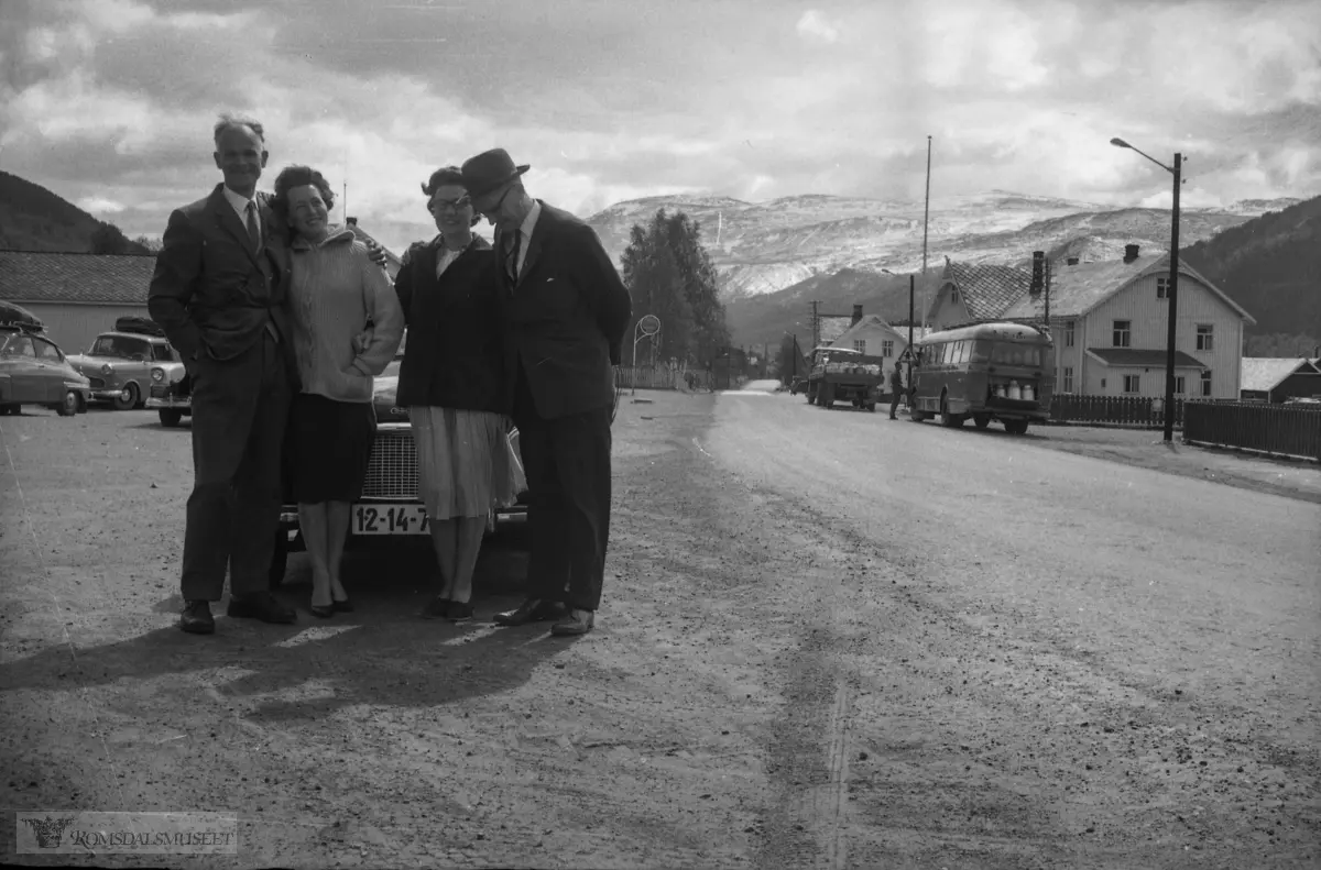 "Landsmøte M.V 31.05.1964". .Musikkens Venner..Dette bildet synes å være tatt i Dovre sentrum og vi ser sørover mot fjellet Jetta. Veien går gjennom sentrum i dag som tidligere, men det er bygd ny E-6 til høyre nærmere Gudbrandsdalslågen. Bak til venstre går det vei opp til Dovre Jernbanestasjon.