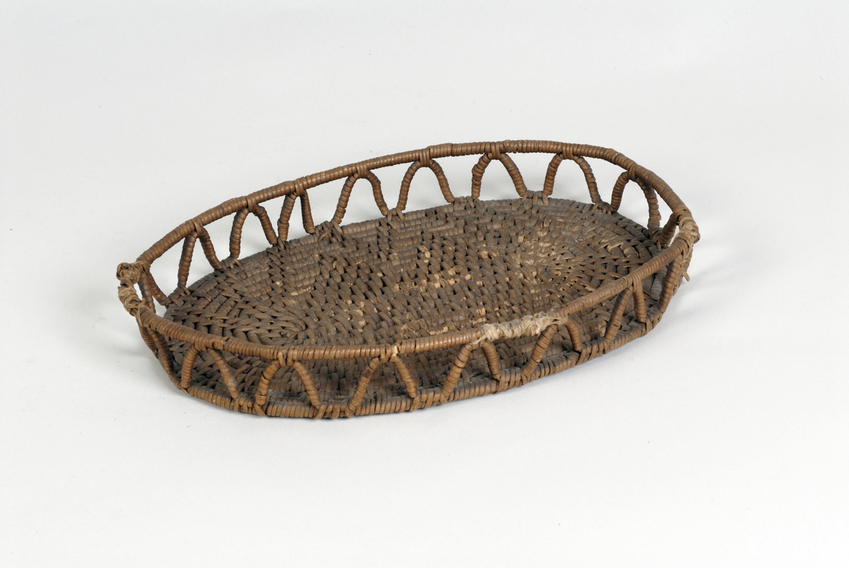 Oval brødkurv. Bunnen i tett mønsterbinding. Gjennombrutt side med siksak bord. 