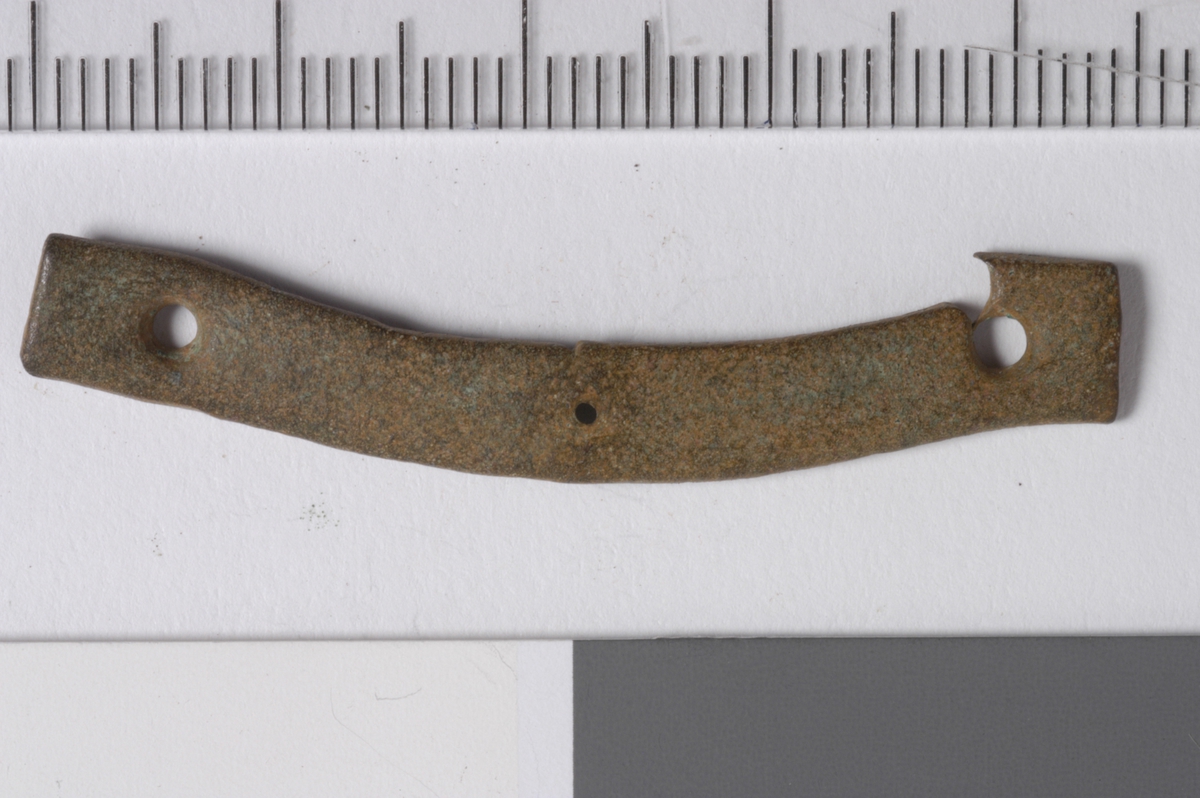 MALV: L. 44, 5  B. 6, 5 MM, SVAKT BØYET, BÅNDFORMET. HULL I HVER ENDE. UTENDEKOR. 