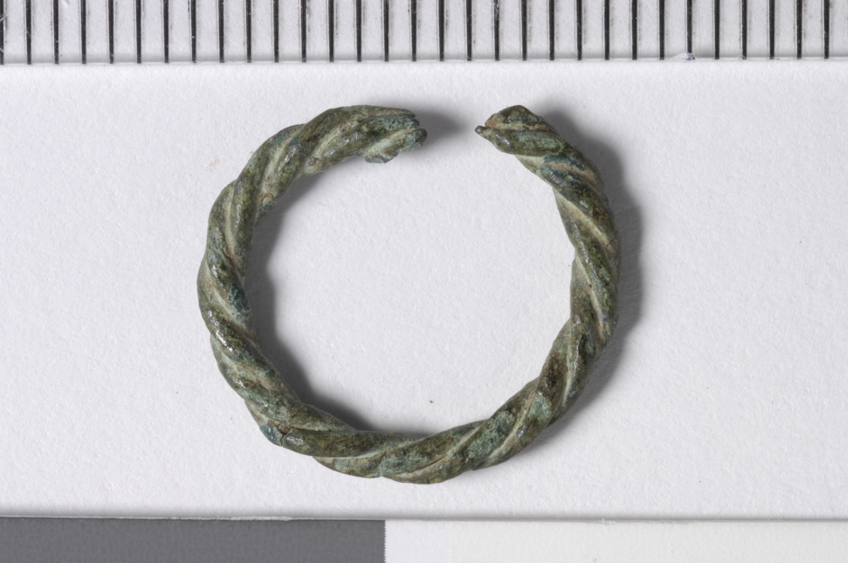 MALV: DIAM. 15  T. 2 MM, ÅPEN RING LAGET AV 2 TRÅDER SOM ER SNODD SAMMEN(SOM "SNODD TAU"). ENDENE AVBRUKKET. TORNEN MANGLER. SE C. 34 775 AI ARKIVET. 