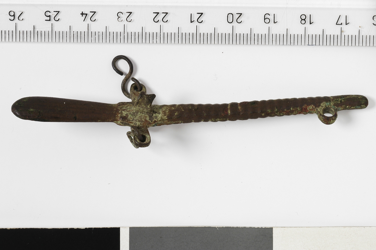 MALV: L. 97 MM, SELVE VEKTSTANGA UTSTYRT MED GRADER, I FORM AV SMÅLIKE VULSTER BORTOVER, ANTAGELIG FOR ET FLYTTBART LODD. UTSTYRT MEDØRER FOR OPPHENGIG AV KJEDER OG VEKTSKÅL. ET LEDD AV TO KJEDER HENGERFORTSATT PÅ. 
