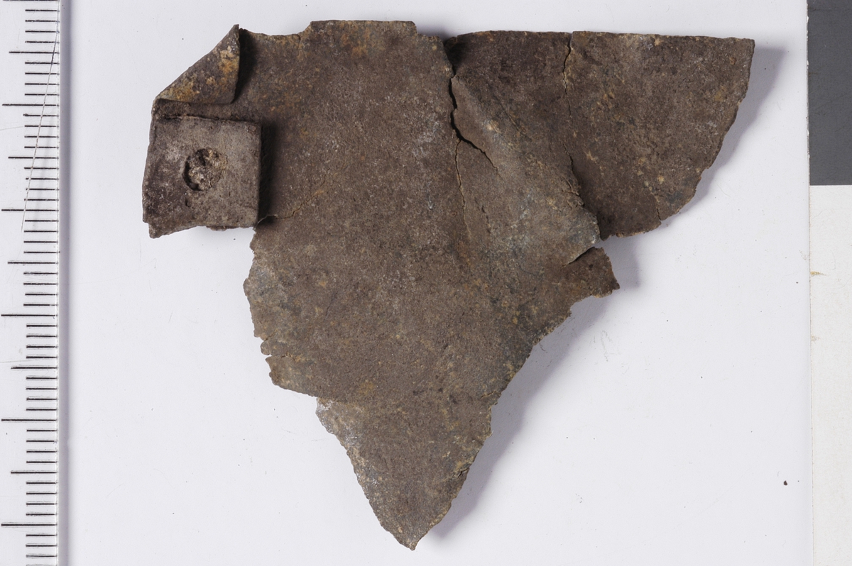 MALV: L. CA. 57 MM, TYNN PLATE, AVBRUKKET, MED TO SIDER I RETT VINKELPÅ HVERANDRE. PÅ DEN ENE SIDEN SITTER ET OMBØYET, KVADRATISK ØRE MEDHULL. 