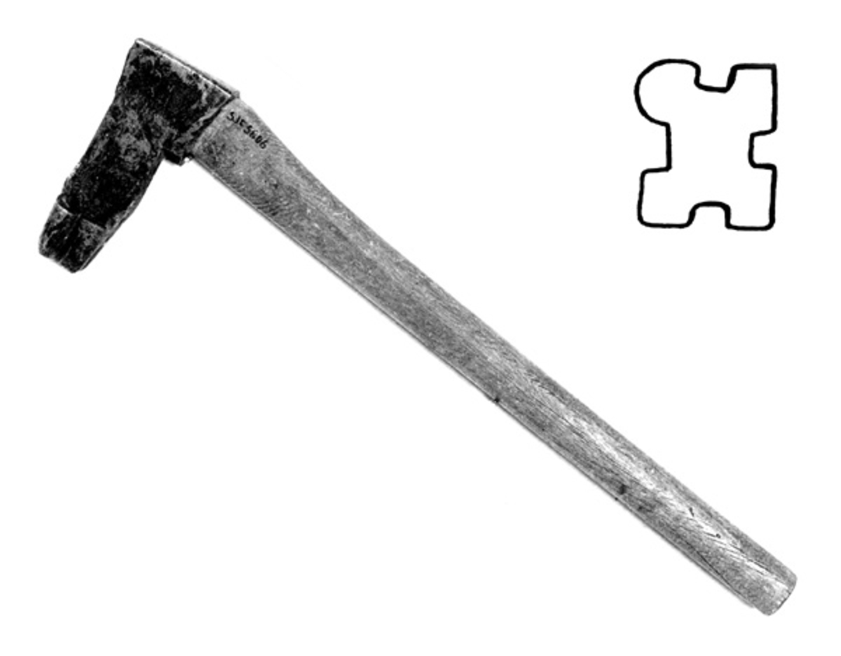 Øks, brukt til å påføre stokkene et merke som gjorde det mulig å identifisere kjøperne (eierne) av stokkene etter annamming og utislag i fløtingsvasdrag. Denne merkeøksa har et 18,3 centimeter høyt blad med 8,7 centimeter lang og 3,5 centimeter bredt (bakerst) nakkeparti. Øyepartiet (skafthullet) er noenlunde triangulært, 4,7 centimeter høyt og 1,6 centimeter bredt i fronten, noe videre bakover. Kjakene (det stålet som omgir øyets bredsider) smalner noe mot den nedre delen av bladet. Nederst på bladets venstre side (sett i øksebrukerens perspektiv) er det utsmidd en 4,5 til 6,5 centimeter høy stålsko med fasslipt, profilert egg. Figuren har tre kvadrete og ett avrundet hjørne. Dette symbolet ble brukt på tømmer som Klevfos Cellulose- & Papirfabrik kjøpte med sikte på å få det fløtet i Glommavassdraget. Bladet har ikke noe smedstempel.

Denne merkeøksa har et snaut 65 centimeter langt, noenlunde skaft av bjørkevirke. Som økseskaft flest er det bredest i høyderetningen og smalest i bredderetningen i den fremre enden. Videre bakover blir det gradvis mer rundovalt. Den fremre enden av skaftet er kilet med en trekile, som skulle forebygge at bladet løsnet fra skaftet under tømmermerkinga.