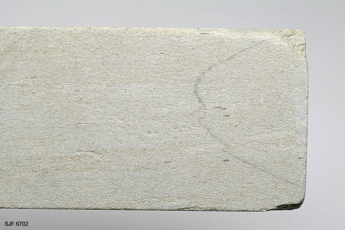 Bryne fra brynesteinsbruddet i Eidsborg i Vest-Telemark. Det er lagd av en lysegrå. finkornert sandsteinsbergart. Formen later til opprinnelig å ha vært rektangulær - 16,1 X 5,2 X 2,9 centimeter - men det er slått vekk noen skår i to av hjørnene. 

Slike bryner var en stor salgsartikkel fra den lille Eidsborggrenda Et parti ble innkjøpt for videre salg i museet.  Form: Rektangulær