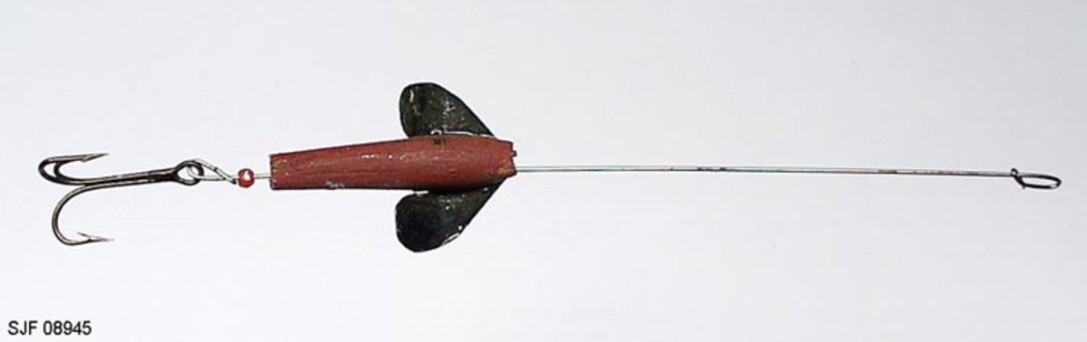 Sluk, devonsluk, av tre. Sluken er hjemmelaget med hull gjennom hele kroppen. Det er ant. en devonsluk. Den er blitt brukt til otring etter abbor. Den ble laget i tre for at den skulle gå i vannskorpa. Sluken har 1 stk. treblekrok. Kroken, treblekroken (trippelkroken), er festet til en metallstang. Metallstanga er ført gjennom den fiskeliknende kroppen. Foran, på sidene av "hodet", er det pålimt vinger (propellvinger), slik at sluken roterer (spinner) rundt sin egen akse. Propellvingene er laget av tynne metallplater. Sluken er bemalt med sølvfarge, rødbrunt og svart.