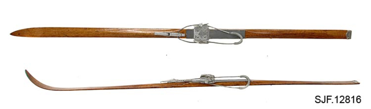 Et par langrennski av heltre, hickory. Skiene er tykkest på midten hvor bidingene er festet (fotsteget). På oversiden har skiene en forhøyning foran og bak bindingene. Forhøyningen strekker seg cirka 42 cm fra forkanten av tåplata mot tuppen og cirka 36 cm fra hælplate bakover mot skienes ender. Sålen på skiene har et langsgående innfrest spor. Sålen er innsmurt med tjære. 

Skiene er utstyrt med Kandahar-bindinger som består av en vaier med fjærtrekk rundt støvelhælen og en strammemekanisme foran tåjernet. Tåjernet er regulerbart, slik at det kan tilpasses ulike formater på skosålene. Strammeren har spor som gjør det mulig å tilpasse bindingen til ulike skostørrelser.  

Tå- og hælplate er festet med små jernstifter til skiene. Trolig er tå- og hælpalta laget av et linoleumsbelegg. 

Det er skrudd fast en metallplate til beskyttelse av skienes ender på hver ski. På metallplata er det gravert inn en stilisert skiløper. Skiparet er festet sammen med to tøyreimer. Skiene ble gjort smalere en gang på slutten av 1940-tallet.

Det er festet to skistropper til skiparet. Disse er røde, hvite og blå.