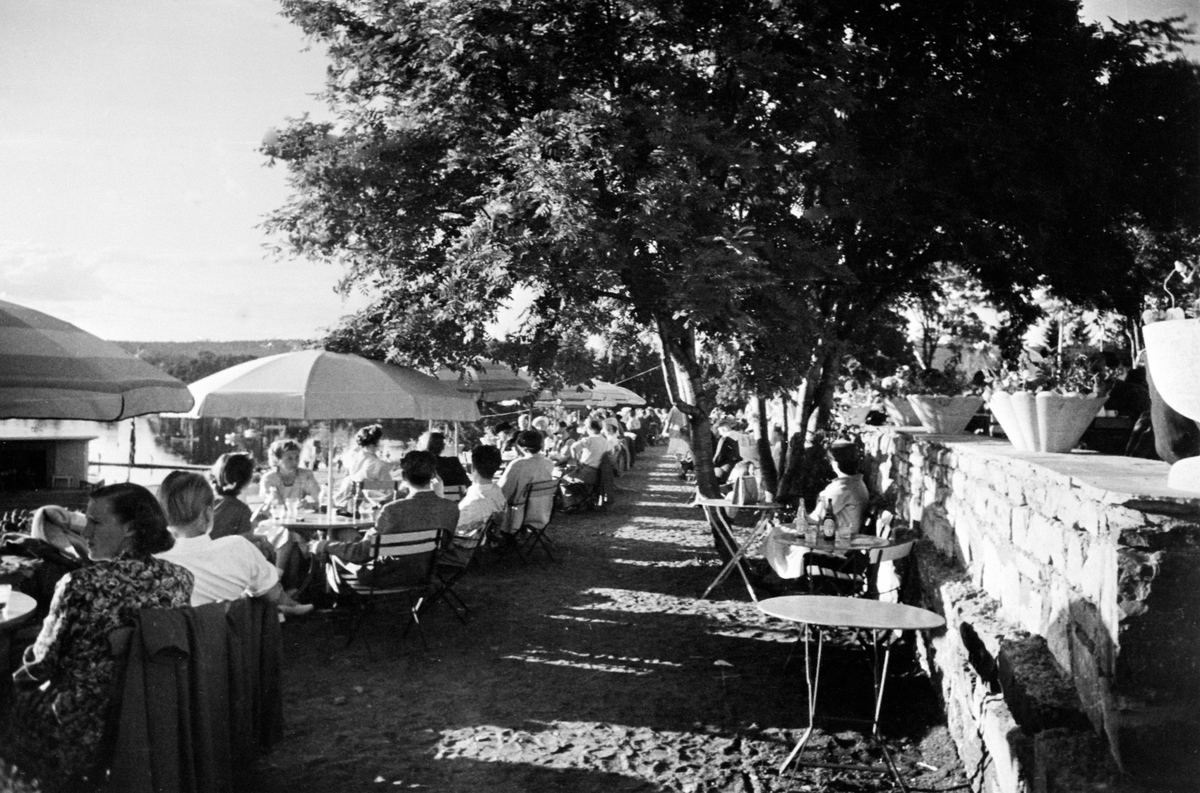 Hamar, Domkirkeoddden, kafeteria med uteservering, besøkende på restaurantterrassen under parasoller,