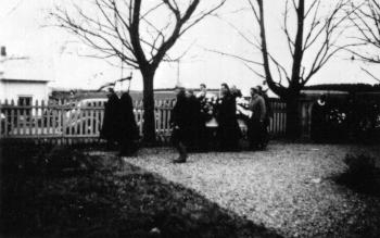 Begravelse på Stavsjø kirkegård, Nes, Hedmark. Kranser og blomster. Folk. Kise østre. Fra venstre er Gunvor Dahl, Gunnar Skredshoel, Else Skredshoel, Konrad Skredshoel, Tora Skredshoel. Begravelse etter Mons eller Tina Skredshoel, døde samme år.