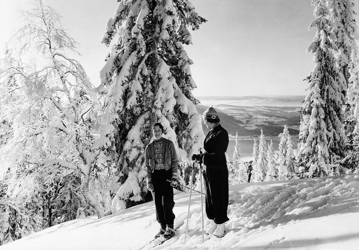 Postkort, To unge damer på ski i Høsbjøråsen, Furnes, Ringsaker. Snødekte trær.