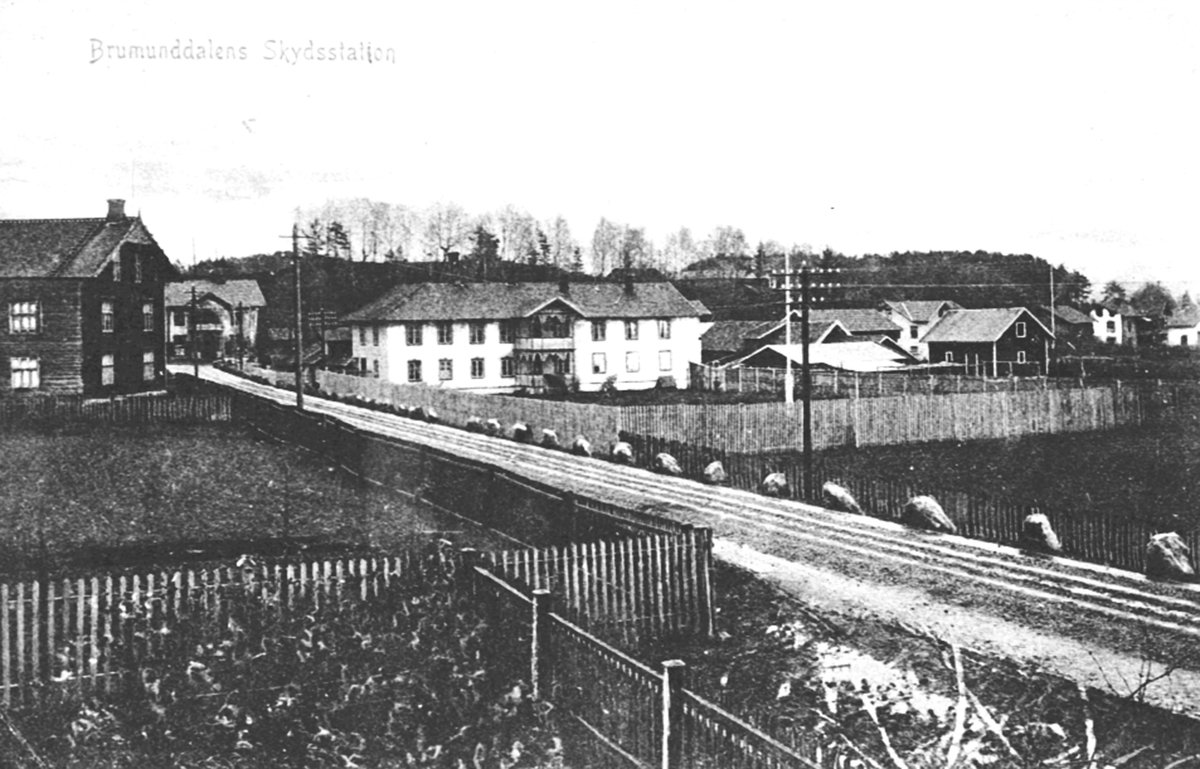 Brumunddal Hotell, skysstasjon, Øverbakken, Brumunddal. Stabbesteiner, stakittgjerde. Helgeby til venstre. Furnesvegen bygd i 1880-85.