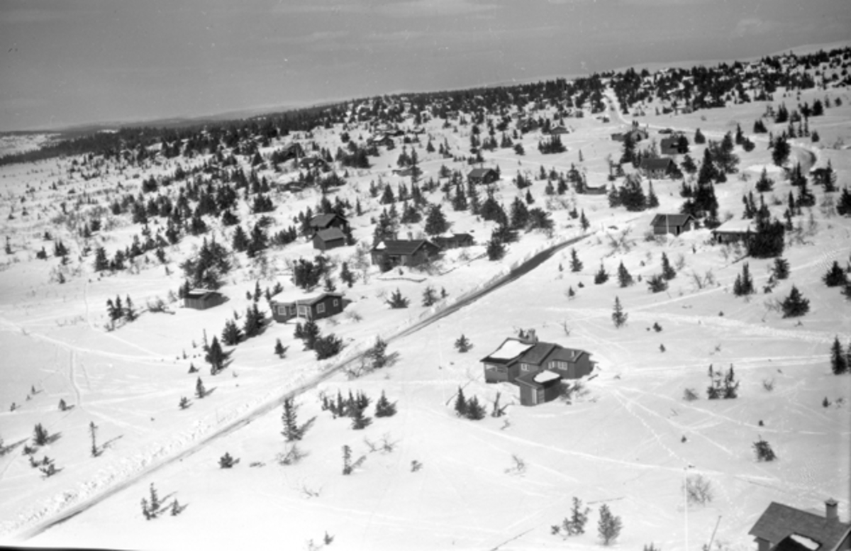 Flyfoto av bebyggelse i vinterlandskap på Ljøsheim, Ringsaker Almenning.