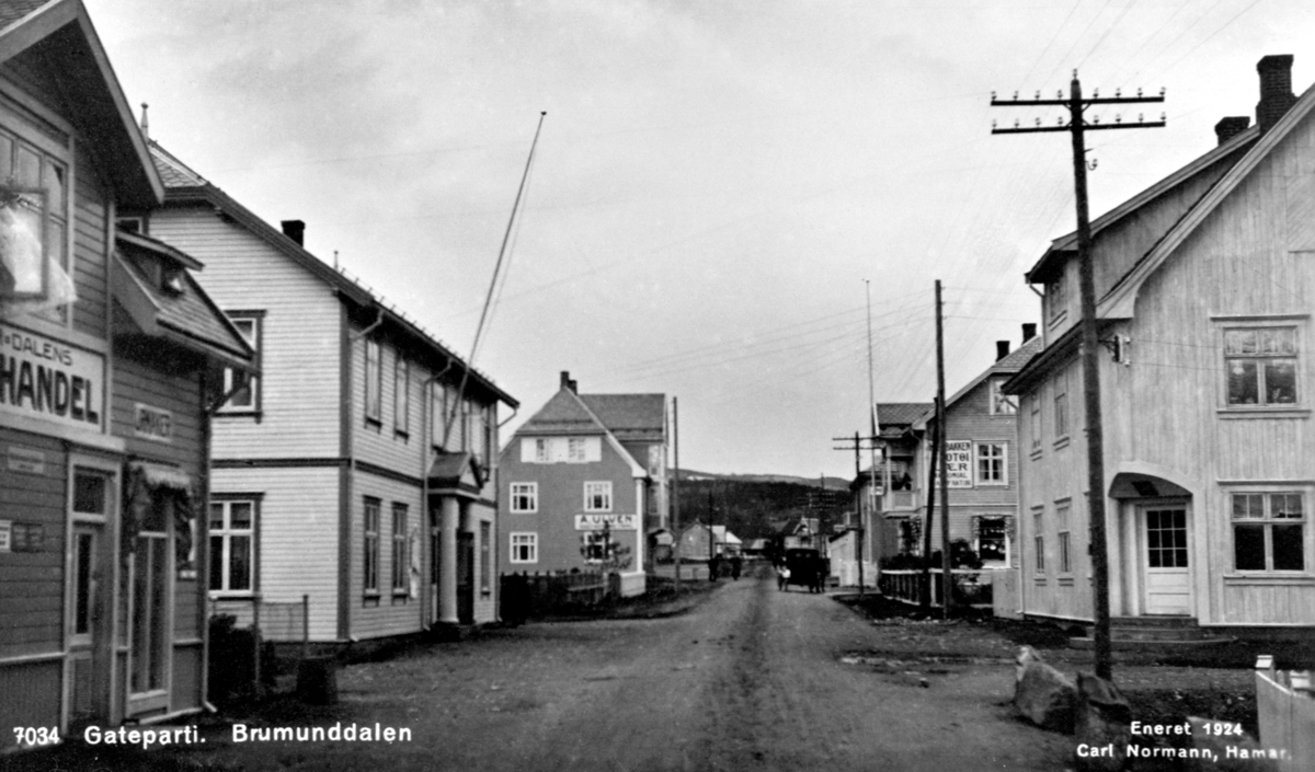 Postkort, Oversikt Nygata, Engerland, Brumunddal. Brumunddalens bokhandel, urmaker Enger, Framheim kino og forsamlingshus, Volla: A.Ulvens skotøyforretning. Til høyre er Poppely, Aker: posthus 1917-22, Søbakken, apotek.