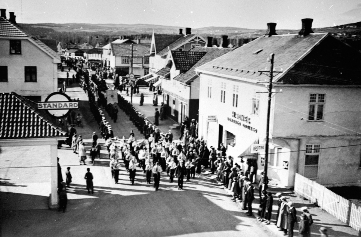 Sangerstevne, marsjerer med korps i spissen, Furnesvegen ved urmaker Sønes, Brumunddal.