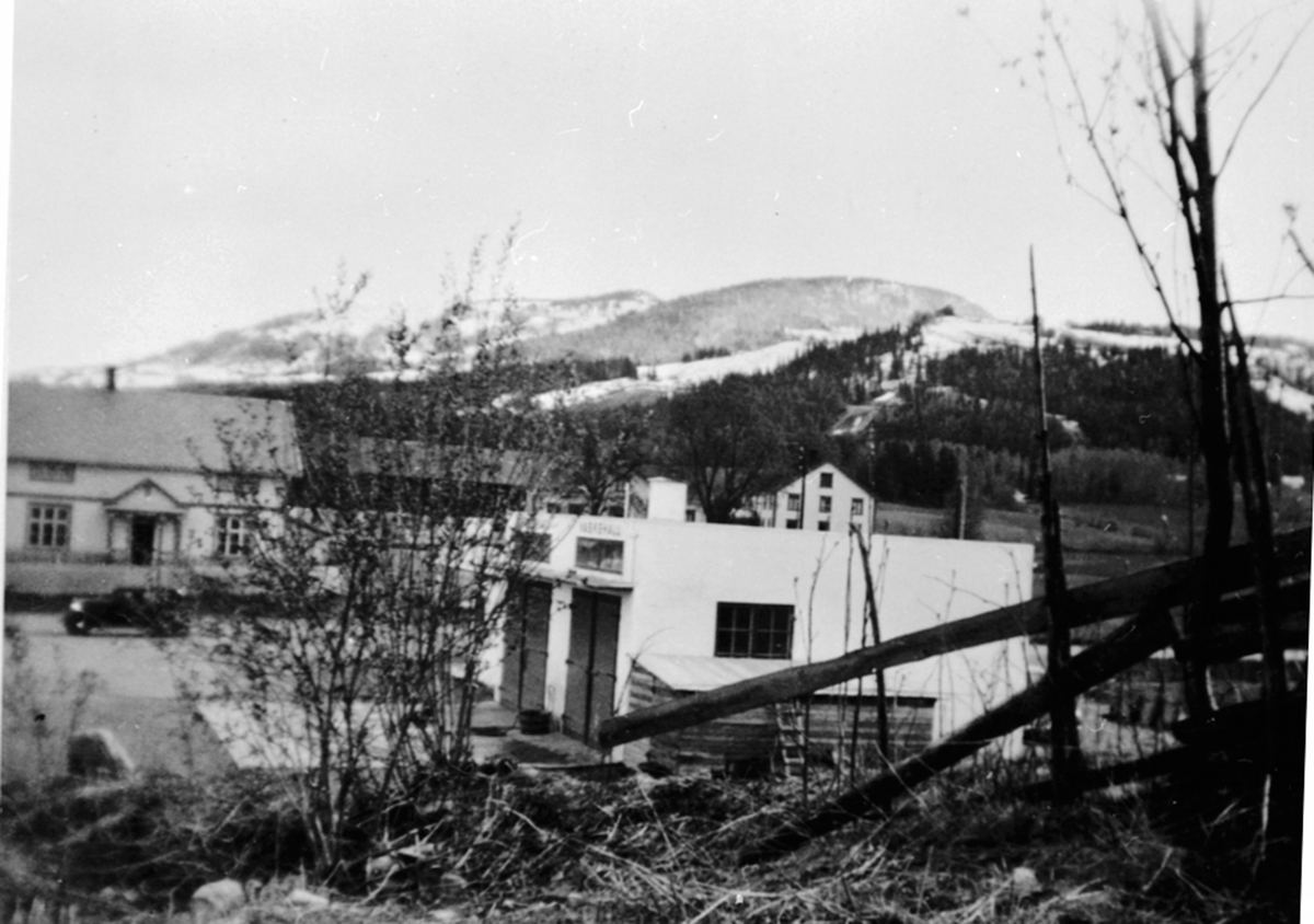 Oversikt, Martin Bakkens bensinstasjon, Finsdal, telefonsentralen til venstre, Buttekvern gård i bakgrunnen, Brumunddal.