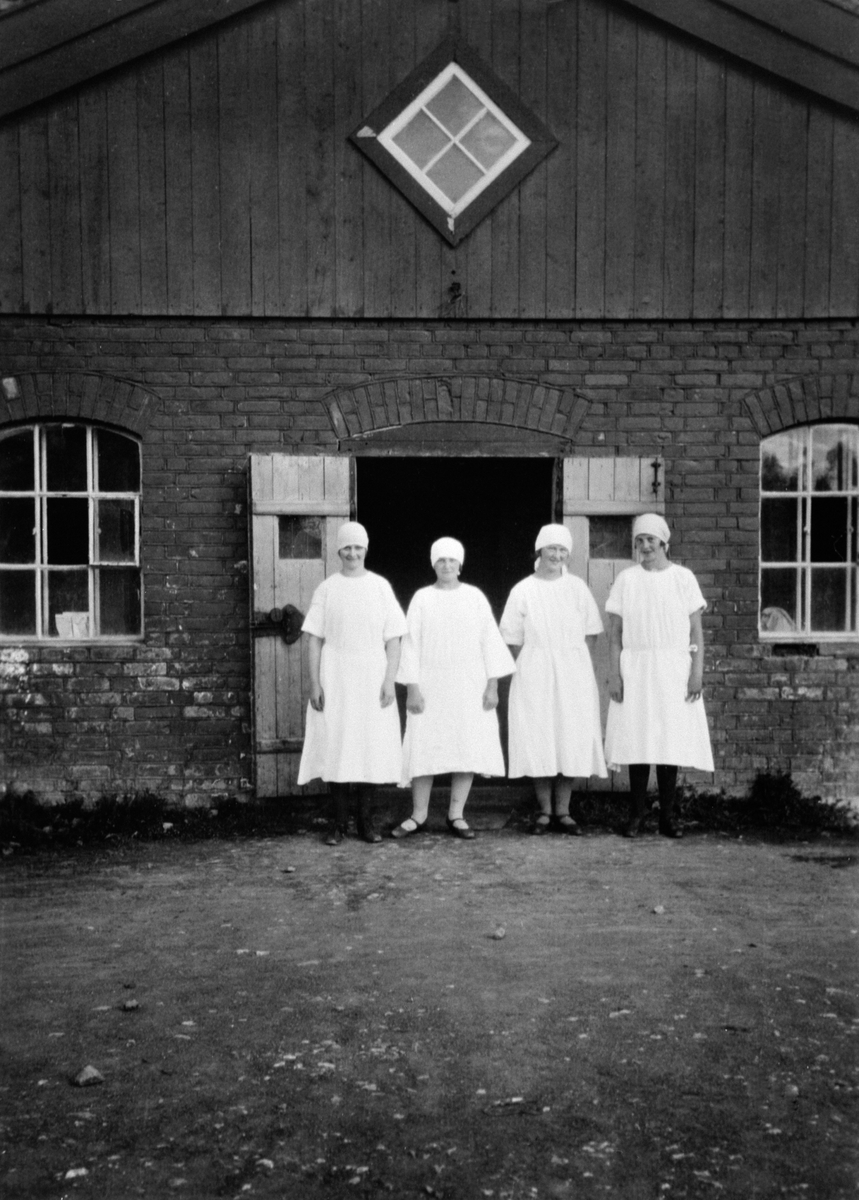 Fire budeier i fjøsdøra på Skredshoel, Ringsaker. Fra venstre er Marie Pettersen, Anna Pettersen, Klara Pettersen, Mina Brendbakken.