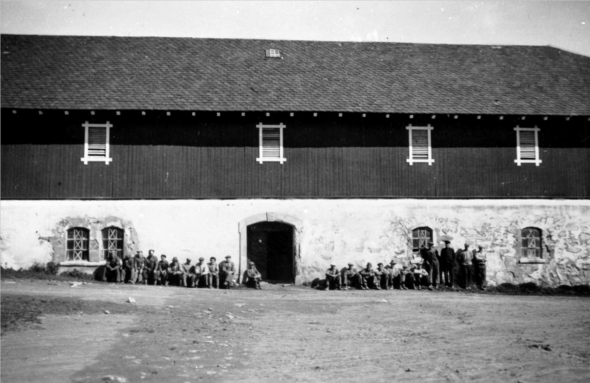 Stor gruppe arbeidskarer foran låven på Grefsheim, Nes, Hedmark.