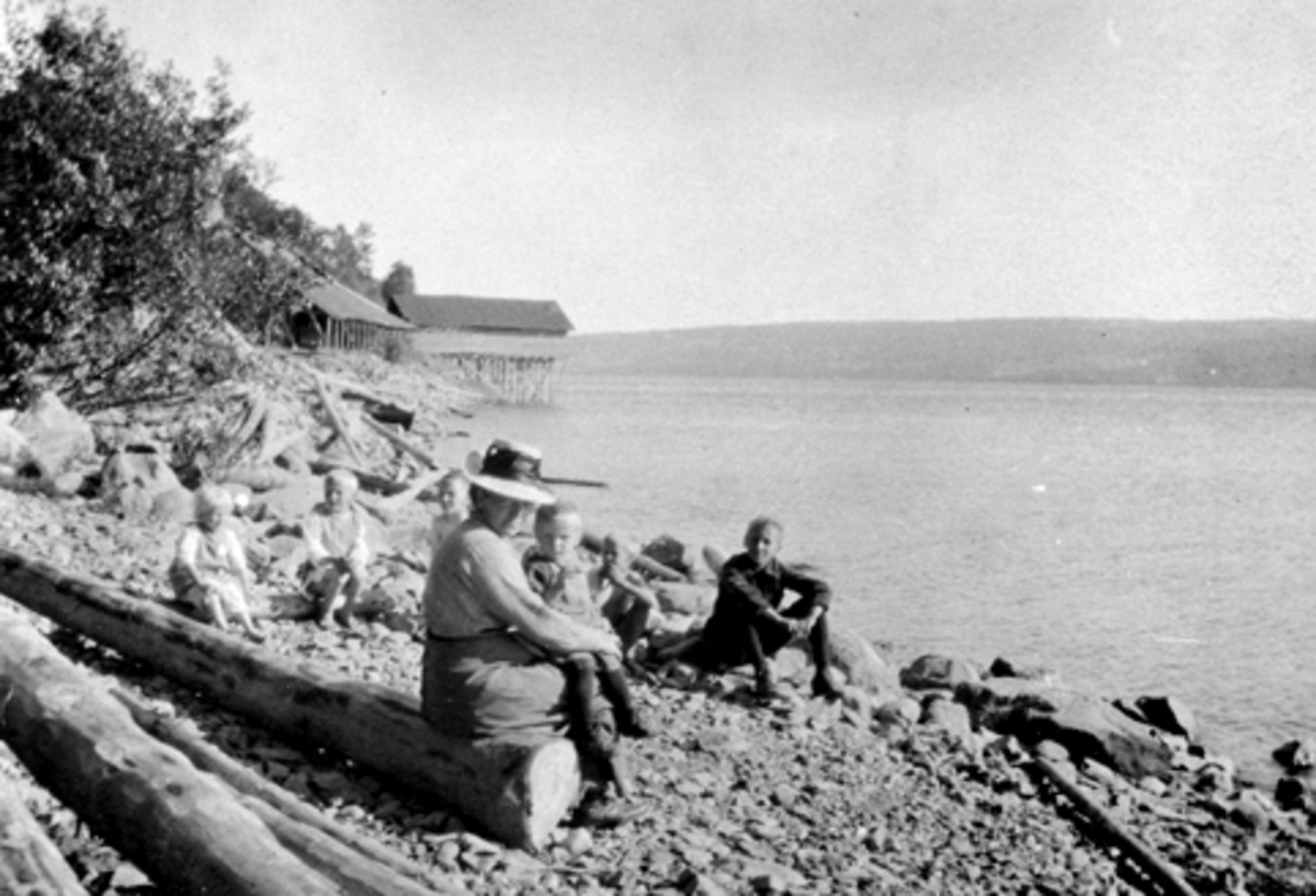 Søndagstur. Louise Sendstad (1881-1955) med tre barn. Sendstad teglverk, Nes, Hedmark i bakgrunnen.