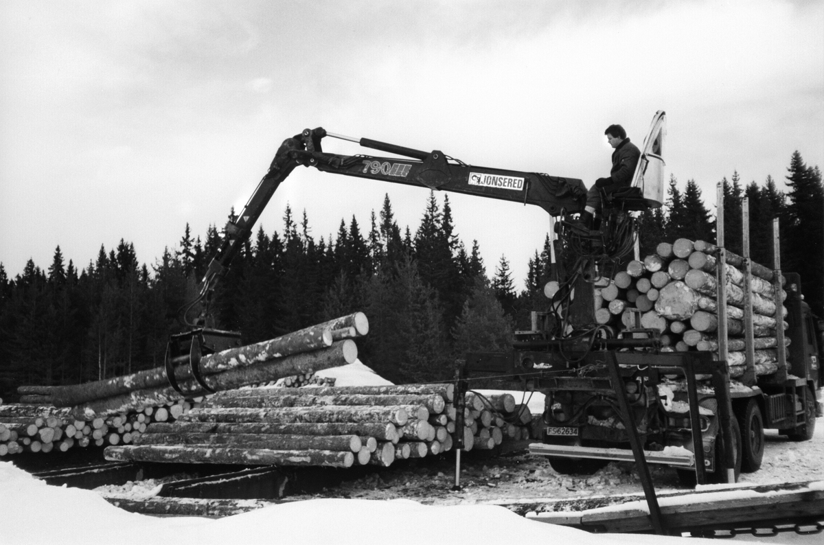 Laster tømmer på lastebil, tømmerkran Jonsered 790, kranfører Olav Fredlund, Furnes Almenning.