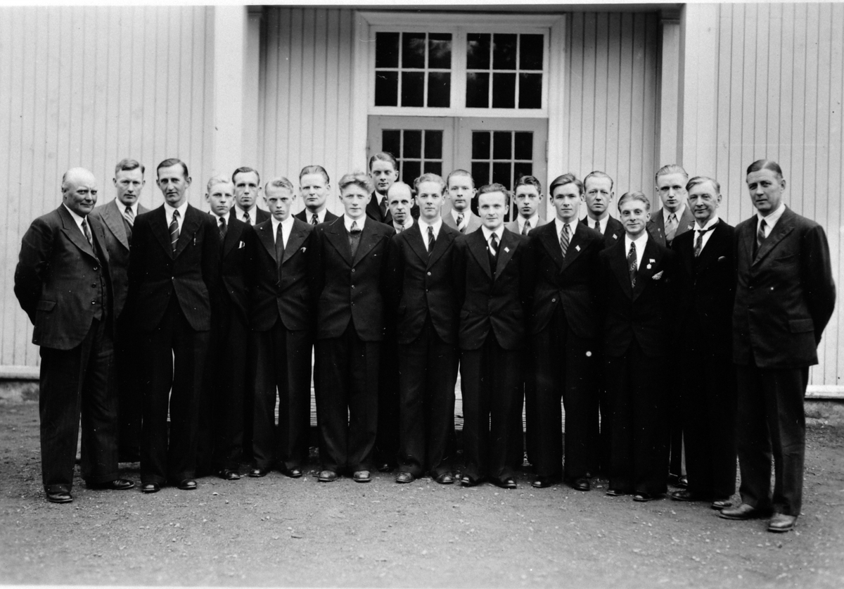 Moelv tekniske kveldskole ved Kilde skole, Moelv i 1938. Fra venstre er lærer Holger Jøsang, Einar Lindsbekken, lærer Helge Nilsson, Kjell Hermannson, Aksel Bjerken, Sverre Antonsen, Kåre Olafsen, Nils Rønning, Leif Pedersen, Kristian Gumundsen, Thorbjørn Larsen, Tormod Jøsang(?), Kristian Kamperud, Asbjørn Kristiansen, Magnus Mikkelsen,  Arne Haugli, Gerhard Fratntzen, Klaudi Bjerken, lærer Petter Nyhus, lærer A.L. Honnæss.