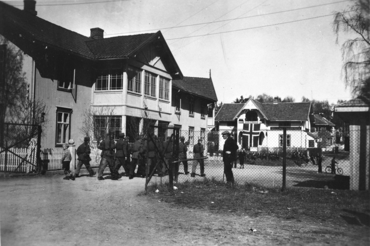 Moelv sentrum, fredsdagene mai 1945. 
 Et skjeldent syn fra maidagene 1945. En tysk tropp marsjerer ut fra jernbanestasjonen fullt bevæpnet.. Det norske flagget henger fra balkongen på Ringsaker Sparebank. Etter kapitulasjonen opptrådte tyskerne disiplinert og ingen episoder inntraff i Moelv.
