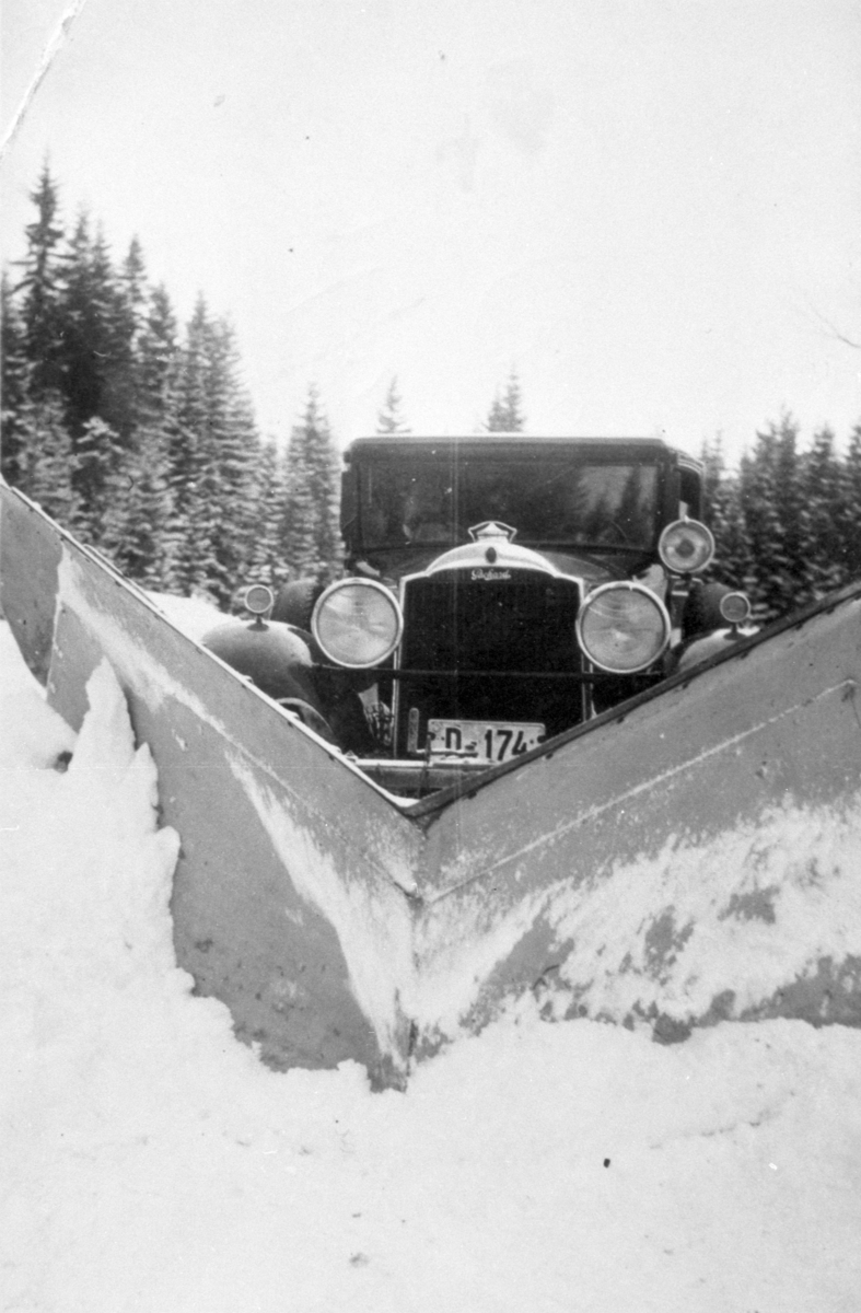 Personbil reg. nr. D-174, med snøplog, snøbrøyting, Ringsaker. Når vegen skulle brøytes ble det ofte brukt store kraftige amerikanske personbiler. Denne er en Packard 1930 som tilhørte Otto Berge i Gaupen. den gikk som drosje og buss. Bilen hadde motor på 6, 3 l og 8 sylindret motor på 145 h. k.  Se Moelvboka utgitt 1986, skrevet av Ove Johansen.