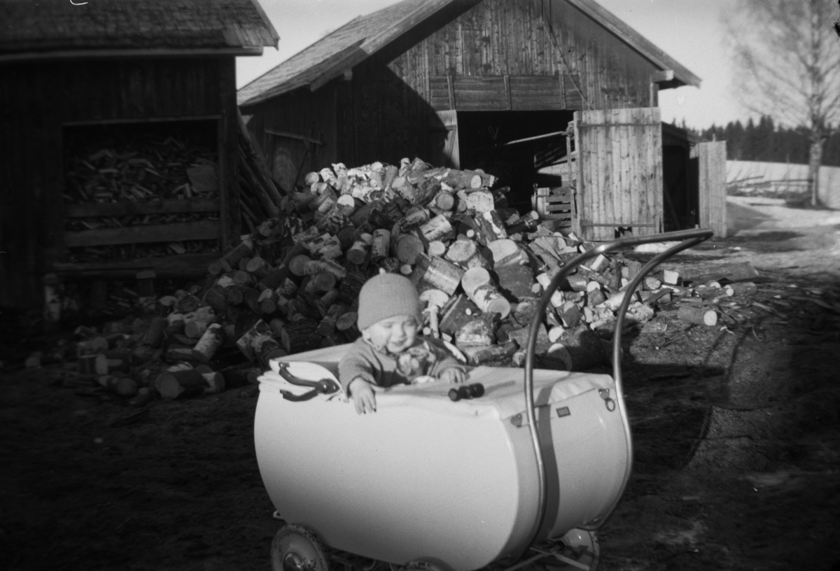Søndre Tomter (Ner-Tomter) våren 1950. Ole Jacob Tomter i barnevogn. Vedhaugene til gardens forbruk. Vedskålen til venstre ble brukt til ved for kjøkkenet (Småved). 