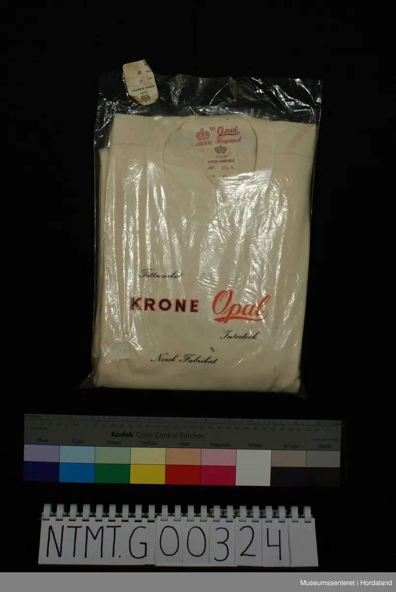 Rund hals, lange ermer med brotavslutning, kile under ermer, skulderstykker.