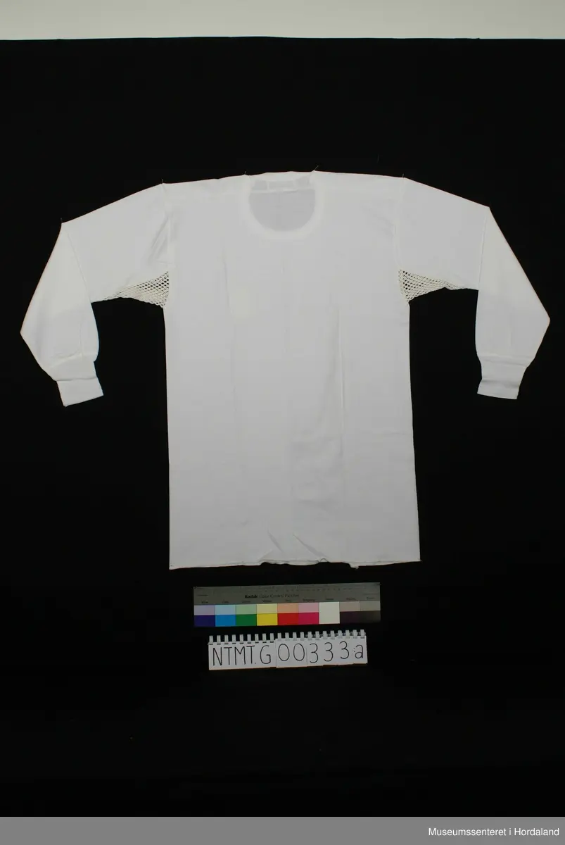 Lange ermer med brotavslutning, rund hals, skulderstykker, kile under ermer.