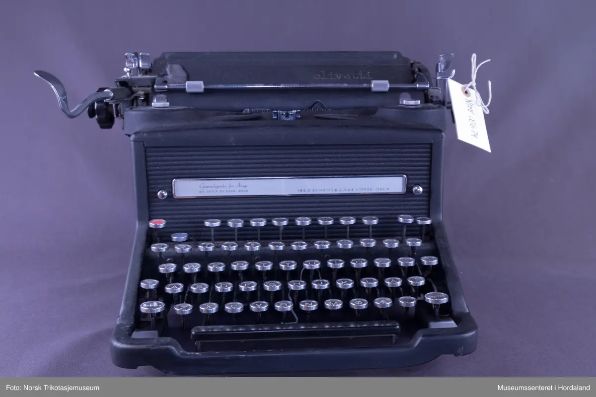 Olivetti standard skrivemaskin, svartlakka med fornikla delar. Valsebreidde 11 tommar. Desimaltabulator. Pica skrift.