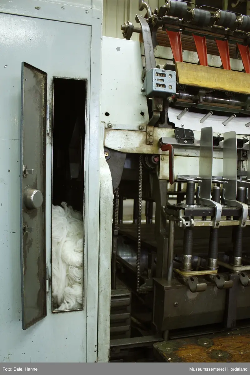 Elektrisk ringspinnemaskin (1958) frå det sveitsiske selskapet Rieter. Øvst på maskina plasserer ein spolane med forgarn frå kardemaskina. Reint teknisk er det tre hovudelement i spinninga:  forgarnet blir strukke, tvista (snodd) for å få meir styrke, før det ferdige garnet blir oppvikla på ein spole eller 'spinnepipe'. Tråden går under eit transporthjul i tre, gjennom støypte løpegangar og vidare nedover: Garnet blir snodd ved at garnet passerer ein løpar som beveger seg på ein ring, før det blir samla på ein sylindrisk metallspole. Det er ei rekkje små støvsugarar langs heile maskina, små røyr som stikk ut over spolane. Desse syg til seg støv og/eller tråden viss den ryk, for å unngå at den kjem inn i maskina. Trådrestar og støv blir samla opp i eit oppsamlingskammer på venstre sida av maskina. Der er det òg ein målar som måler kor mykje maskina spinner.

Drivverket og ein stjernemotor sit på høgre sida av maskina. På sida står det "Rieter" i raudt, og det er to målarar som måler omdreiingar/hastigheit på maskina. Det er ei rekkje med 136 koner på kvar side. Maskina kan byggjast på i seksjonar, og slik utvidast etter behov, noko som er vanleg for spinne- og spolemaskiner.