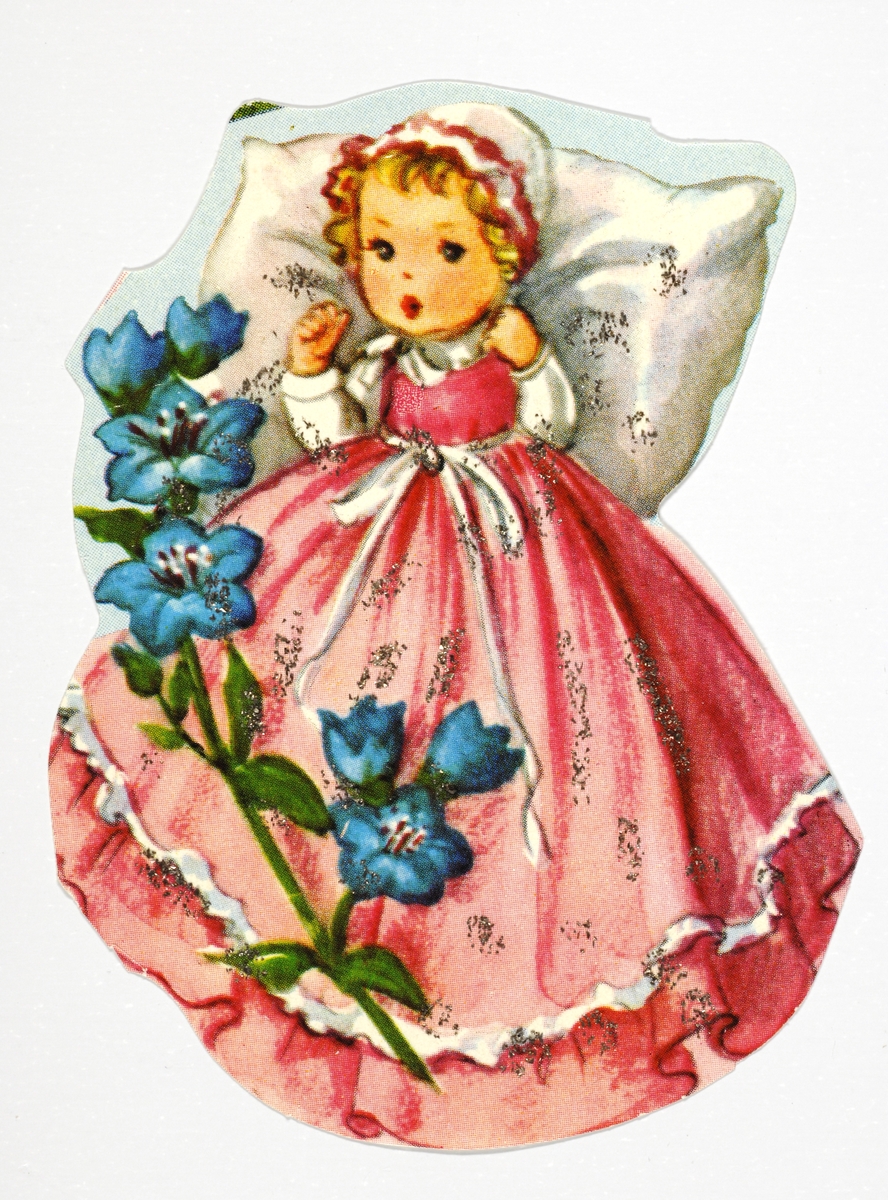 En liten jente ligger med hodet på en pute. Påkledd med kyse og lang kjole. I forgunnen en blomstergren.