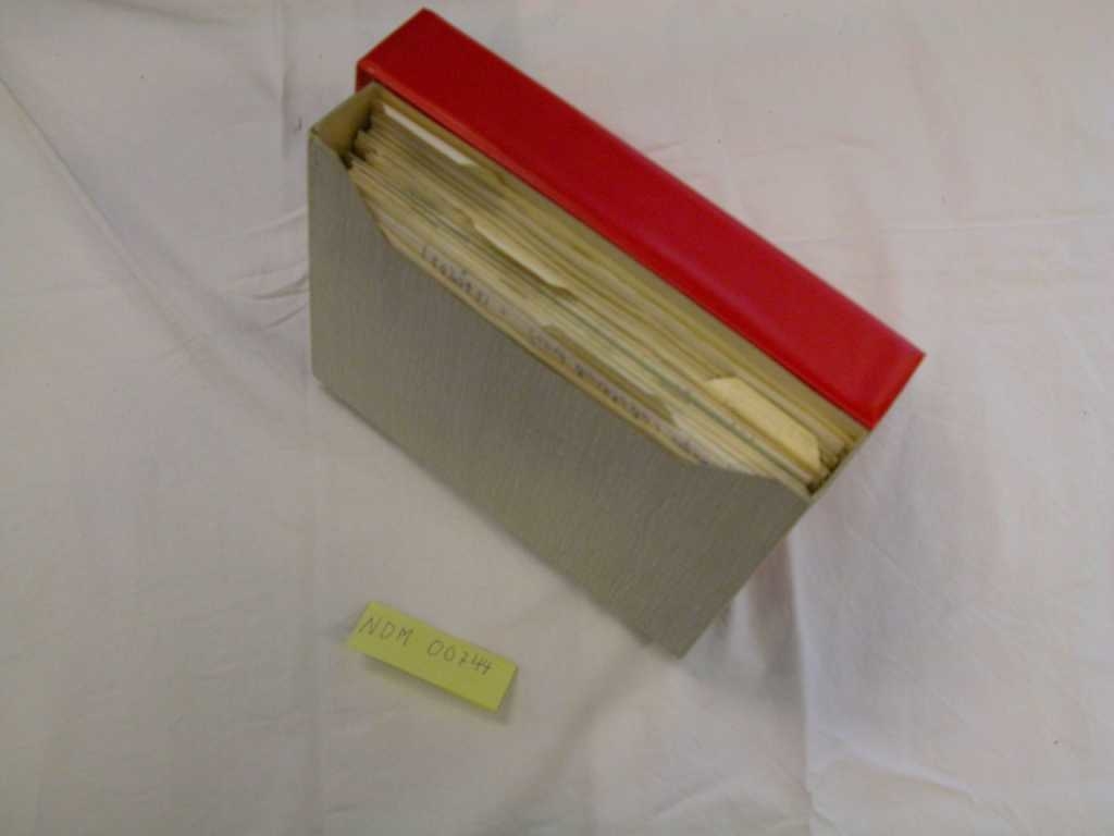 Rød NKS-perm med skolearbeid.