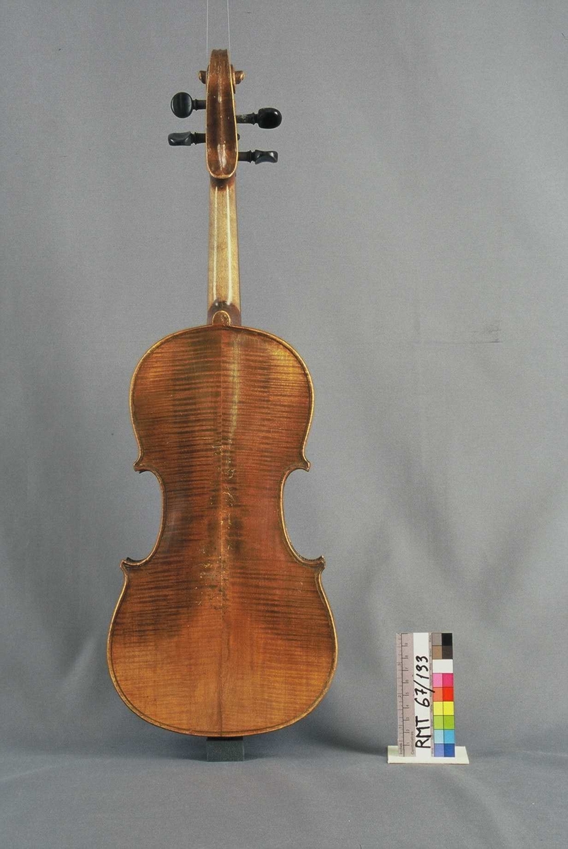 Strengeinstrument i mindre størrelse, 1/4 format(?). Lokk av gran, bunn og sarg ahorn. Lys lakkert. Gripebrett, strengeholder og endeknapp ibenholt. Sortmalte skruer. Mangler hjørneklosser.