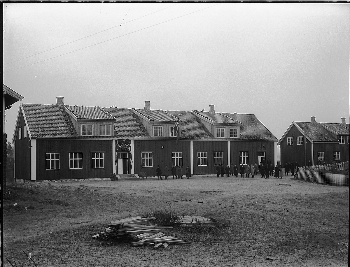 HAMAR JERNBANESKOLE. DISEN. EKSTERIØR. FOLK PÅ TUNET. JUST BROCHSGATE 13. Skolebygningen ses til venstre, lærerboligen til høyre. Bildet er antagelig tatt på åpningsdagen 1. november, 1920. Pyntet med norske flagg. 