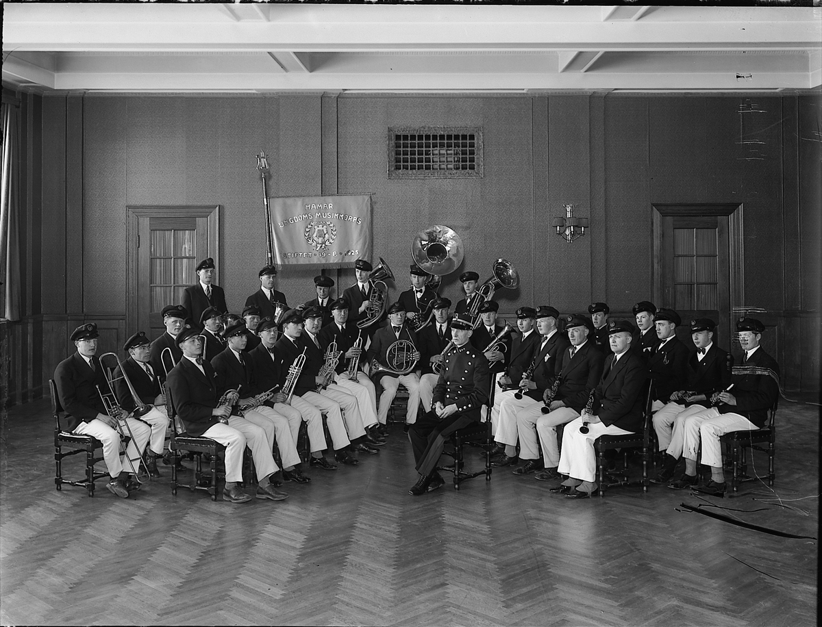 HAMAR UNGDOMSKORPS. GRUPPE MED DIRIGENT. UNIFORMER. FOTOGRAFERT I INTERIØR. 