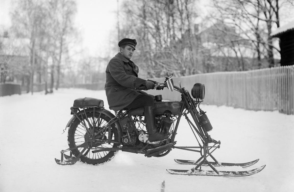 Hamar, Høiensalgata, ingeniør Sverre Hagen bygde om en Harley Davidson motorsykkel med meier for vinterkjøring, bilsakkyndig Mikkel Lie kjører, Sykkelen på bildet er en 1917/18 1000 ccm magnet modell med Acetylene belysning. Carbide tanken for belysning henger på gaffelbeinet.