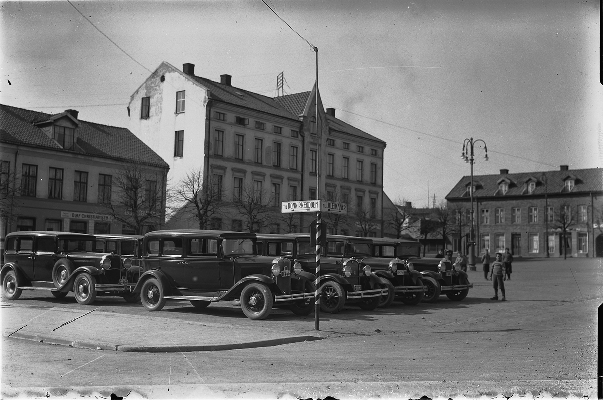 Hamar, Stortorget, krysset Storhamargata og Kirkegata, drosjeholdeplass, Aasgården i bakgrunnen, D-462, D-444, D-113, D-124, vegskilt til Domkirkeodden og Lillehammer for riksveg 50 som gikk gjennom byen,