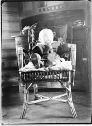 Interiør, stue. En baby sitter i en stol.