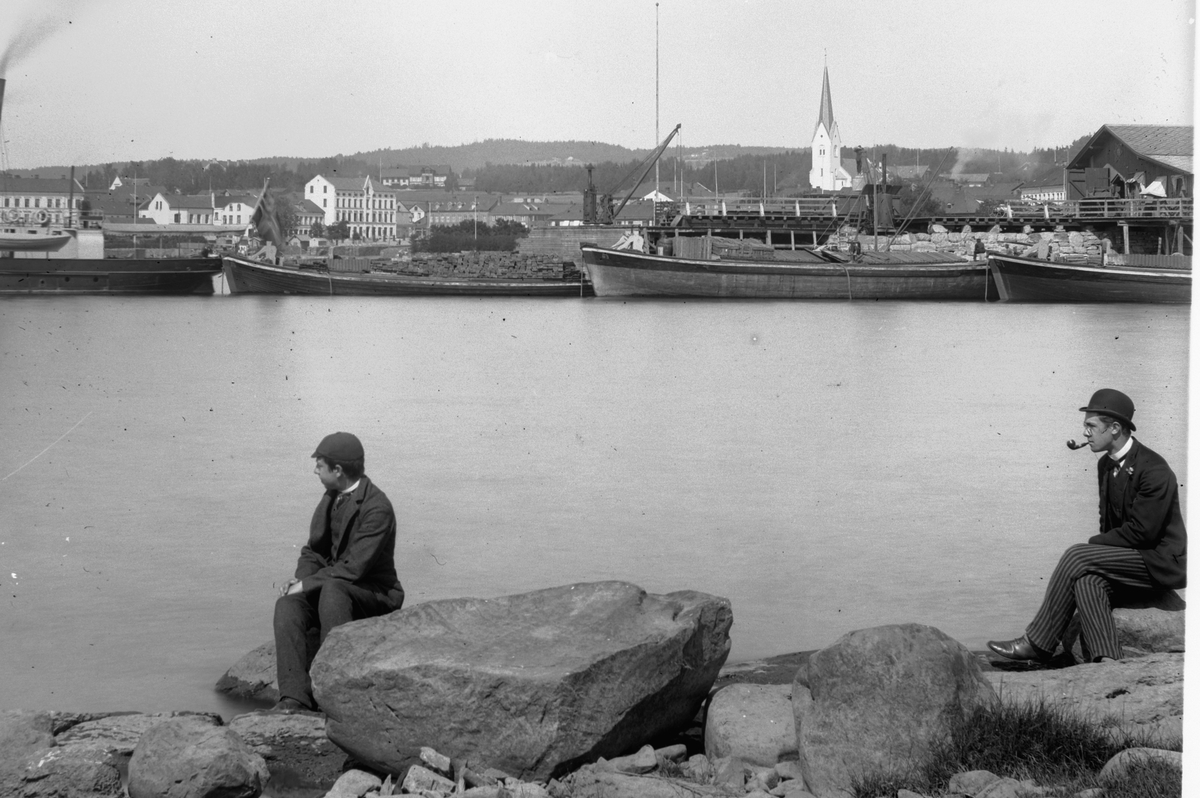 Jernbanebrygga, Hamar. I forgrunnen til høyre: lege Andreas Erichsen og lege Edvard Erichsen, sønnene til stiftsprost Hans Emil Erichsen. Mjøsbåter. Til høyre er laste- og slepebåten Thor og tre godslektere. Thor ble også brukt til isbryting.