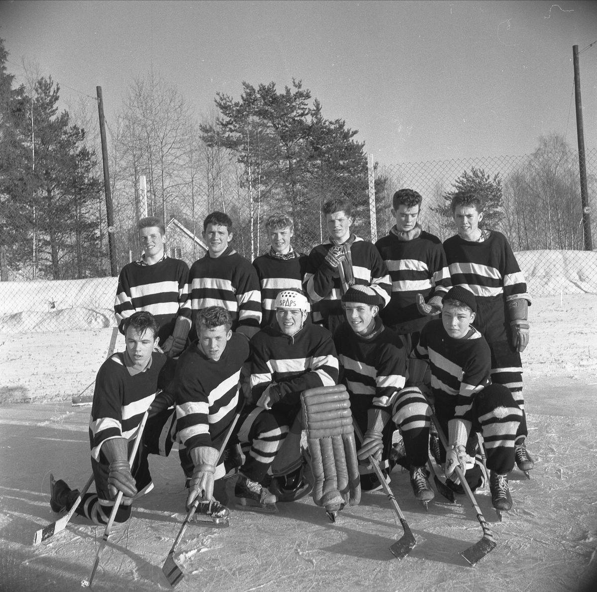 Storhamar, Ishockeyspillere, utendørsbane, vinteridrett. Lagbilde gruppe 11. Hamar Katedralskoles seirende lag i ishockeyturneringen 1959/1960. Første Rekke fra venstre Steinar Johansen, Jan Sindre Larsen, Jon Olav Larsen, Jan Åge Mathisen, Helge Aarflot. Bakerst fra venstre: Sven Ole Flensborg, Per Bøe Bekkevold, Kjell Haakonsen, Edgar Malmann, Terje Kristiansen, Erik Grimsrud.