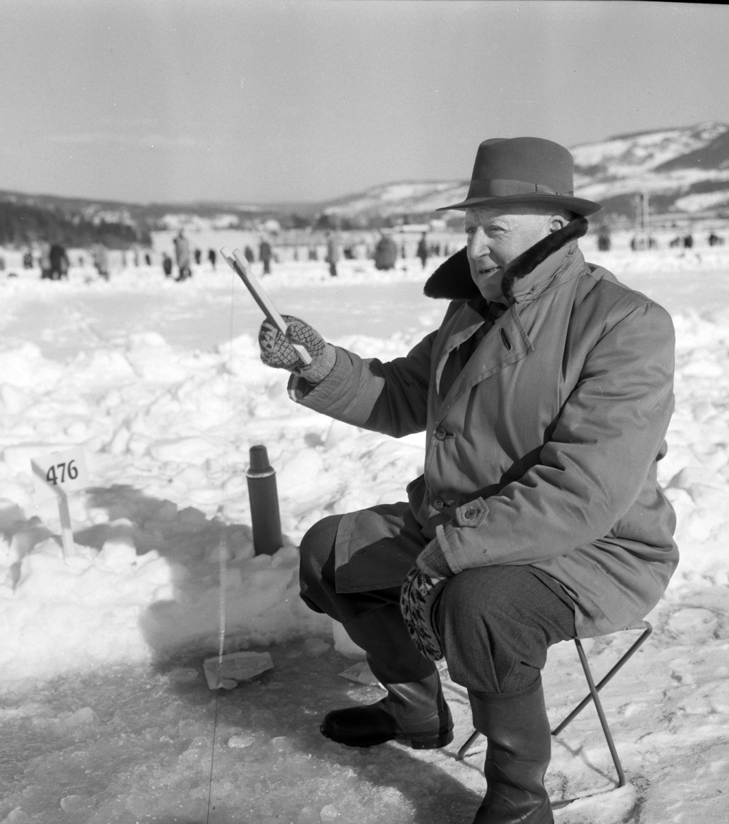 Pilkekonkurranse utenfor Strandsaga i Brumunddal 09. 03. 1958. Fiskekonkurranse på Mjøsisen. Isfiske. ukjent pilker. 
Premier i pilkekonkurransen var bla. en bil, Skoda 1958 modell, motorsykkel, kjøleskap, reiseradio. Se. Na-00293-31 og Na-00293-32 for flere opplysninger. 