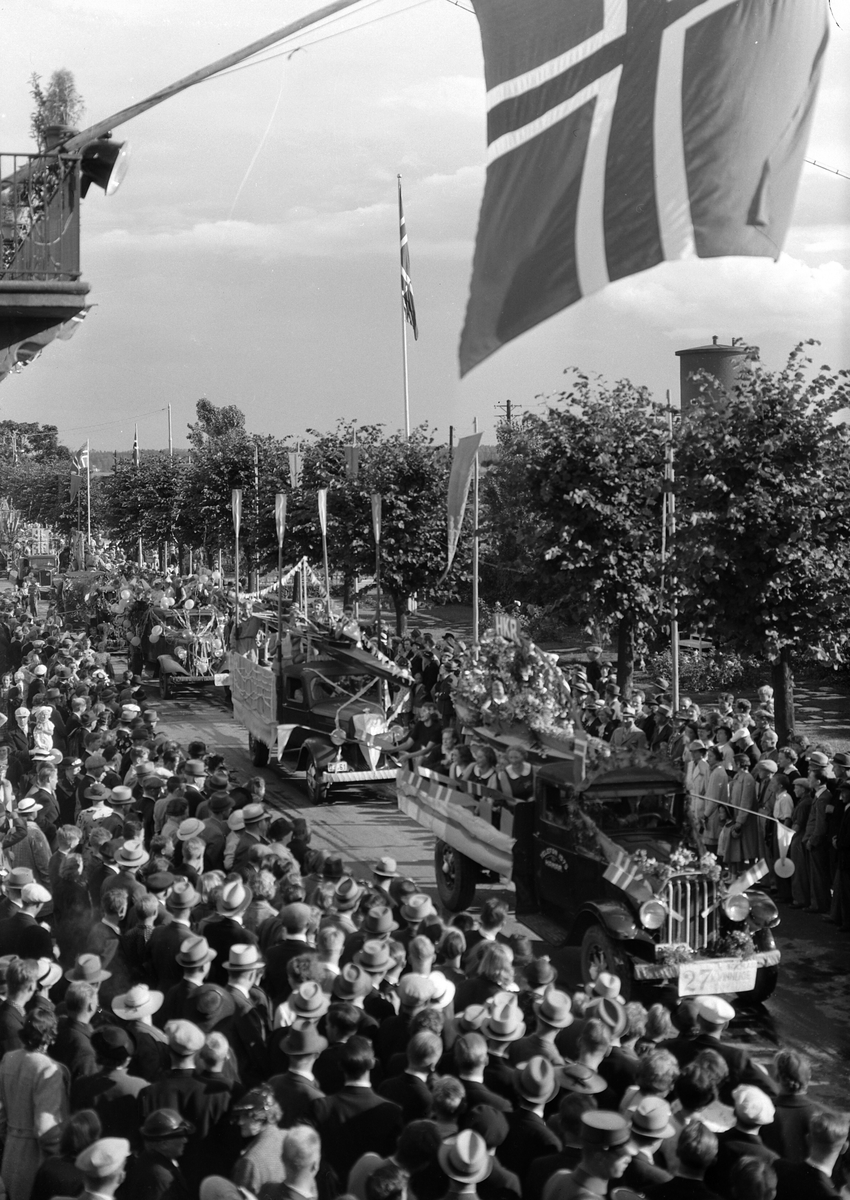 Hamardagen 1939, opptog i Strandgata, Lastebilkortesjen fra Utstillingsplassen til Stortorget, dagen var en todagers fest som samlet 50 000 mennesker, bilkortesje som representerte distriktets handel, håndverk og industri, publikum på fortauet,