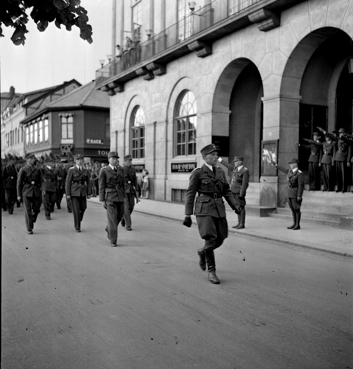 Hedmark Arbeidsfylkings idrettsstevne på Hamar. 27-28 juni 1942. Dette var en organisasjon som prøvde å mobilisere ungdom til å gjøre samfunnsnyttig arbeid. Organisasjonen kom under stor innflytelse fra Nasjonal Samling, NS. Her marsjerer de gjennom Strandgata og forbi Festiviteten på vei til Idrettsplassen. 
Se NO-09172-01 til NO-09172-13. 
