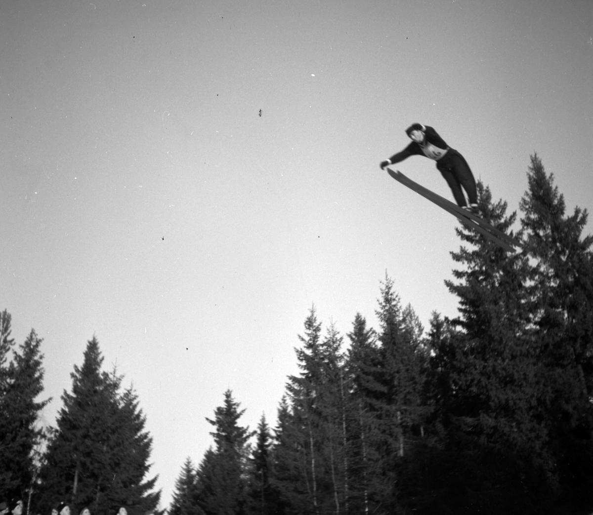 Oplandske skistevne i Frambakken, Brumunddal 17.01.1953. Hopprenn, ukjent skihopper i svevet.