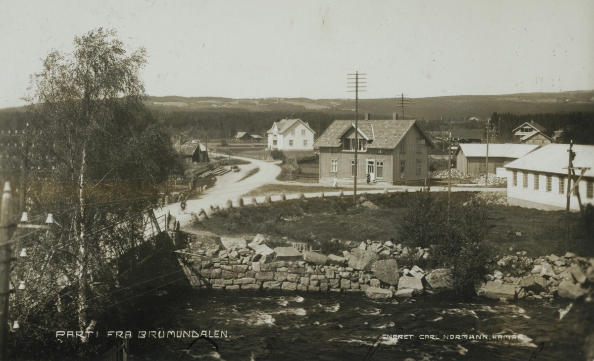 Postkort, Brumunddal, Veldresiden, brua over Brumunda, midt på bildet: Stensgård oppført av Hanna Økelsrud rundt 1920, det hvite huset bak er kontoret til Pihl og til høyre Bro Mekaniske Verksted,